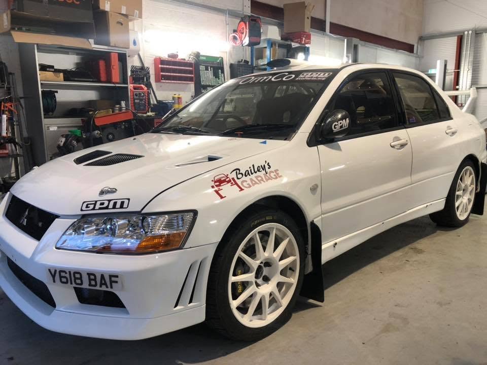 White Mitsubishi Evo rally car with Bailey's Garage livery
